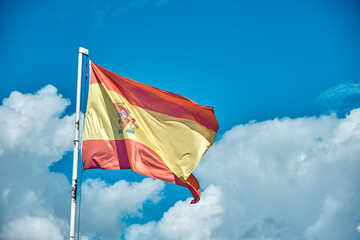 Spanish flag over blue sky with clouds - Constitutional Spanish flag