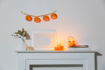 Preparing your home for Halloween. A garland of pumpkins on the wall above fake dresser panel....