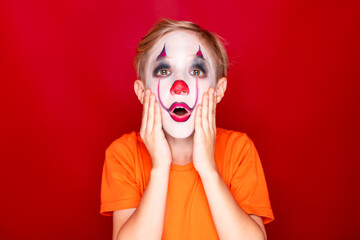 child with makeup, then halloween grabbed his face with both hands in amazement and fear.
