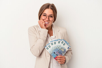 Young Russian business woman holding banknotes isolated on white background biting fingernails, nervous and very anxious.