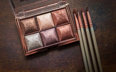 closeup photo of a glittery eye shadow palette with makeup brushes - 459322727