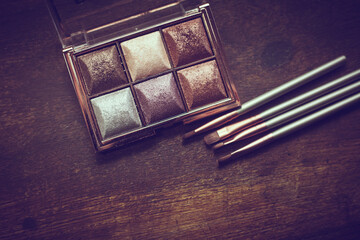 closeup photo of a glittery eye shadow palette with makeup brushes - 459322752