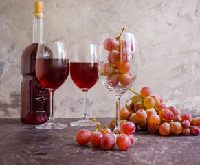 red wine glass, fresh grapes on concrete background
