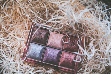 closeup photo of a glittery eye shadow palette with makeup brushes - 459322780