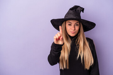 Young Russian woman disguised as a witch celebrating Halloween isolated on purple background showing number one with finger.