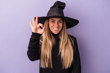 Young Russian woman disguised as a witch celebrating Halloween isolated on purple background cheerful and confident showing ok gesture.