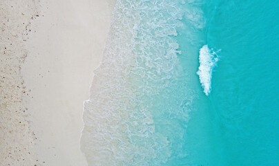 Top view of the beautiful ocean shore with waves and foam on the sand. Seychelles. Texture and background tourism design