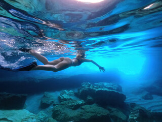 Fototapeta na wymiar Underwater split photo of beautiful volcanic white rock caves with emerald clear sea