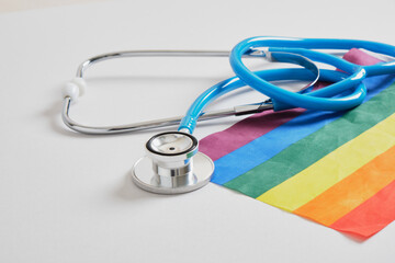 medical stethoscope and lgbtq community flag on gray background copy space