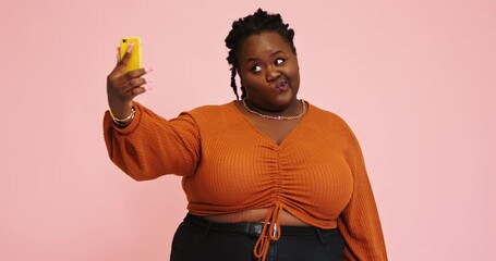 Afro-American plump lady makes selfie changing positions