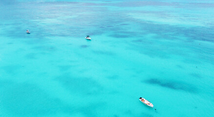 Top view of the gorgeous emerald clear ocean water in the Seychelles. Boats on the water