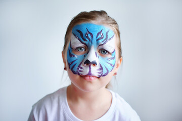 Girl aqua makeup in the form of a blue water tiger zodiac on a white background, concept symbol of the new year 2022, sad portrait. High quality photo
