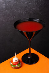 Halloween drink with canapes on orange background