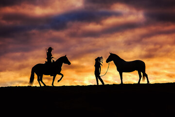 Indian, cowboy and horses at sunset
