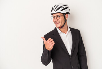 Young business caucasian man holding bike helmet isolated on white background points with thumb finger away, laughing and carefree.
