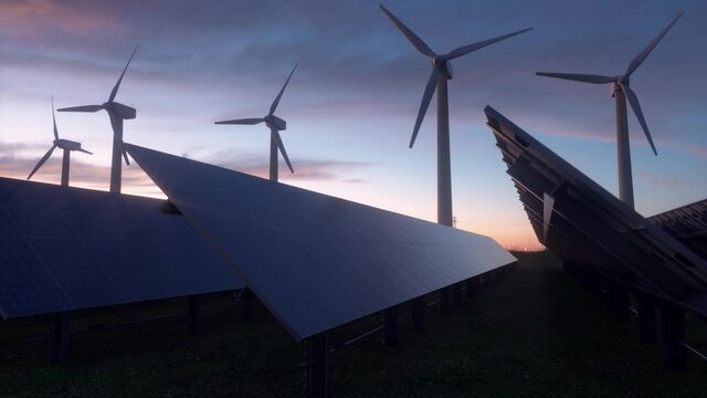 4K Video Renewable energy park. Windmills and solar panels with sunset in the background. 