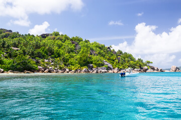 Seychelles, motor boat against the tropical backdrop of the rocky island.