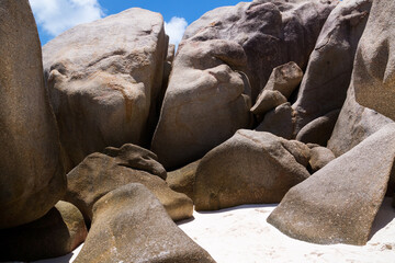 Coastal smooth boulders on the large background of sand.
