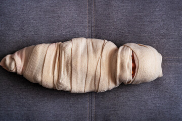 The man is wrapped in a cloth. The body is shrouded in a veil. The concept of a  deceased. Mummy in...