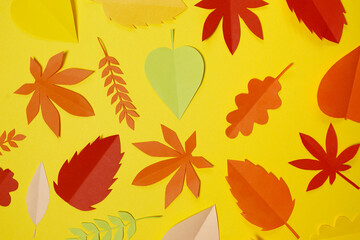 autumn paper leaves fall on yellow background. Handmade origami.