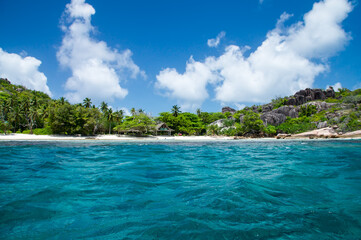 Fototapeta na wymiar Beautiful hotel on the shore of the turquoise waters of the ocean. The Seychelles.