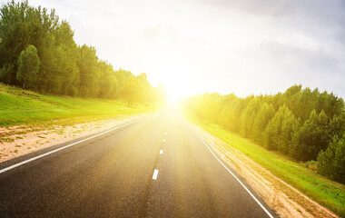 Asphalt road in green forest.