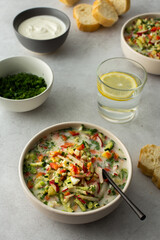 Soup from fresh ripe vegetables with sour milk drink, Russian traditional soup okroshka, top view