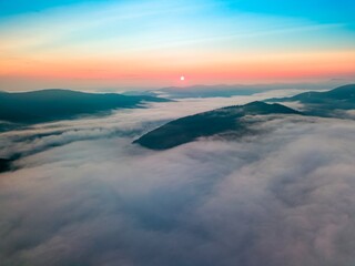 Fototapeta na wymiar Fog in the mountain valley at dawn. Ukrainian Carpathians in the morning in the haze. Aerial drone view.