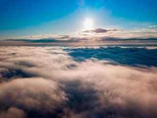 High flight over the fog in the mountains. Ukrainian Carpathians in the morning. Aerial drone view.