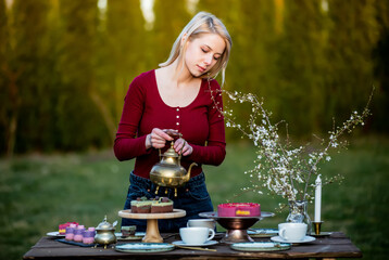 woman pours tea during a tea party in the garden
