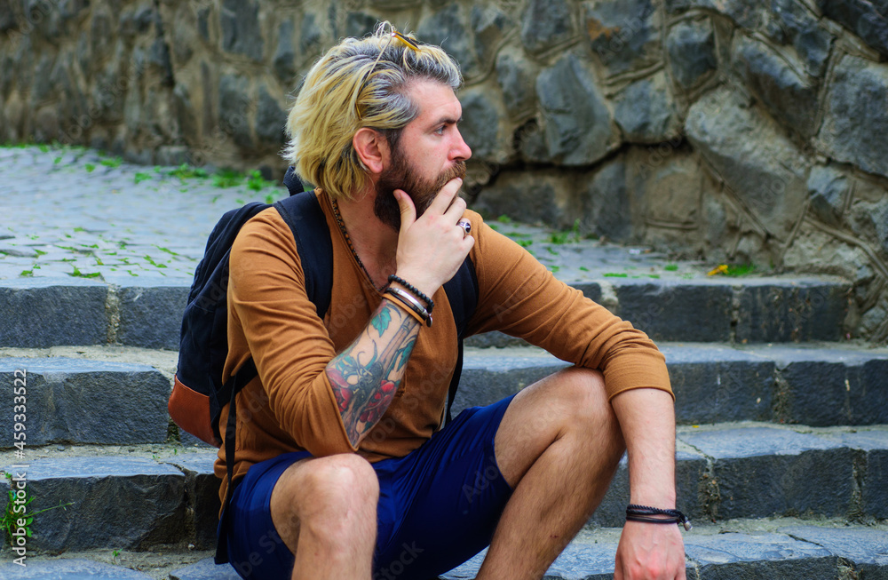 Wall mural bearded man sitting on stairway. stylish guy sit on stairs. thoughtful handsome bearded male relaxed