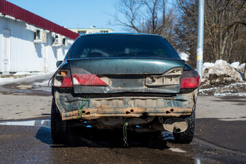 the back of an old car. car after the accident. broken headlights and missing bumper