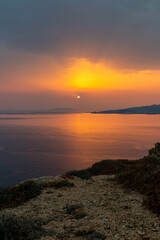 Coastline View of Sun Peaking Through Clouds in Mykonos Greece