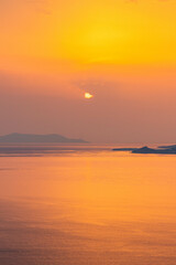 Fototapeta na wymiar Coastline View of Sun Peaking Through Clouds in Mykonos Greece