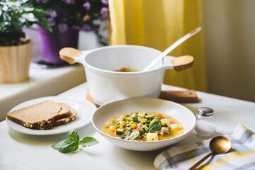 Delicious and healthy traditional italian soup minestrone served in a plate on dining table at the kitchen
