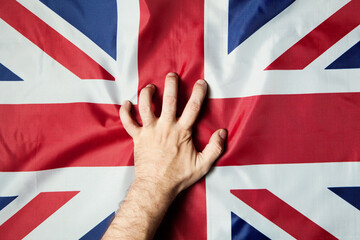 Man's hand on the UK flag. Strength, Power, Protest concept.