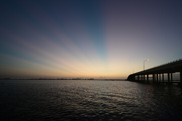 Rickenbacker Causeway Bridge in Miami, Florida under pink sun rays just before sunrise.