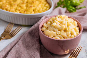 Mac and cheese with basil on top on a rustic wooden board