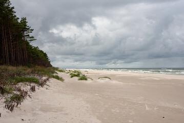 Wide sandy beach under cloudy sky. Baltic Sea, Lubiatowo, Bialogora, Poland. 