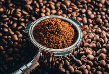 Portafilter on ton of coffee beans with black background