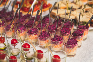 Catering table buffet dinner, beautifully decorated banquet with variety of different food snacks and appetizers on corporate birthday party event or wedding reception, canape, delicatessen setting