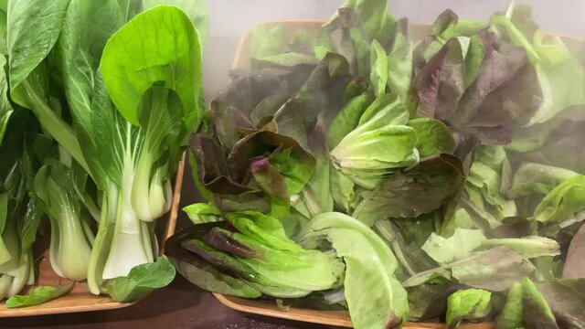Yummy green vegetables ready to be served, chinese cabbage and a bok choy harvesting in basket. Taiwanese fresh vegetables on a tray typically used for Hotpot or Steamboat. Hotpot ingredients.-Dan