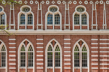 Fototapeta premium Brick wall of an old 18th century building with large windows.