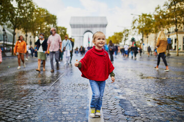 Happy preschooler girl walking in Champs-Elysees in Paris, France - obrazy, fototapety, plakaty