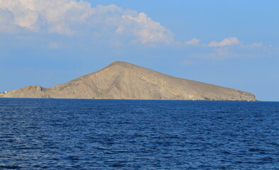 The seashore in sunny weather, a view of the cape and a calm sea. Suitable for photo wallpapers, photo frames and lovers of water landscapes.