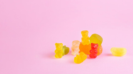Variety of gummy bears candies on pink background