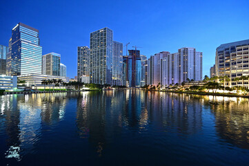 Fototapeta na wymiar City of Miami, Florida skyline reflected in still water of Biscayne Bay in pre dawn light.