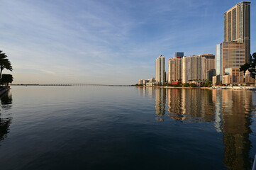 City of Miami, Florida skyline reflected in still water of Biscayne Bay at sunrise.