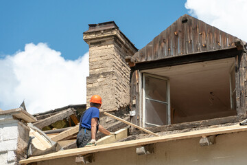 Repair of a wooden roof outdoors on a summer day against the background of blue sky and clouds. A...