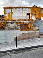 collapsed old house in the old town distrit with remains of yellow ocher colored insulating foam of...